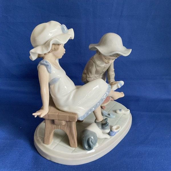 The Figurine Is Rich In Detail And Pleasing To The Eye. The Boy Is Helping The Girl Try On Her Shoes.